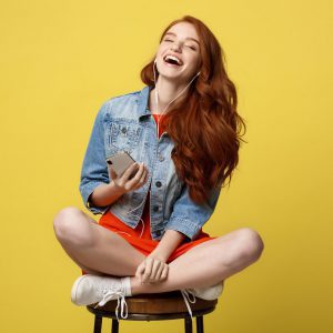A teenage chair sitting on a chair and laughing